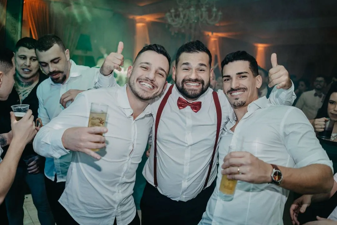 Ενδεικτική εικόνα: τρεις φίλοι του γαμπρού χαμογελούν με τον αντίχειρα ψηλά στη γιορτή
